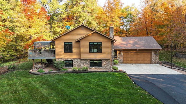 view of front of property featuring a garage, a front lawn, and a wooden deck