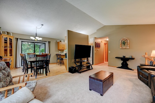 living room with light wood-type flooring, lofted ceiling, and an inviting chandelier