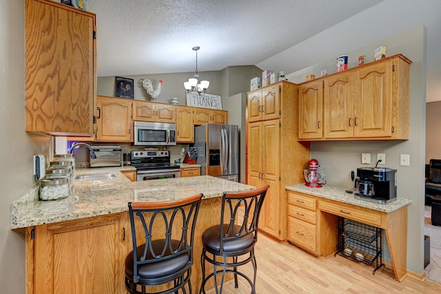 kitchen featuring an inviting chandelier, light hardwood / wood-style flooring, vaulted ceiling, kitchen peninsula, and stainless steel appliances