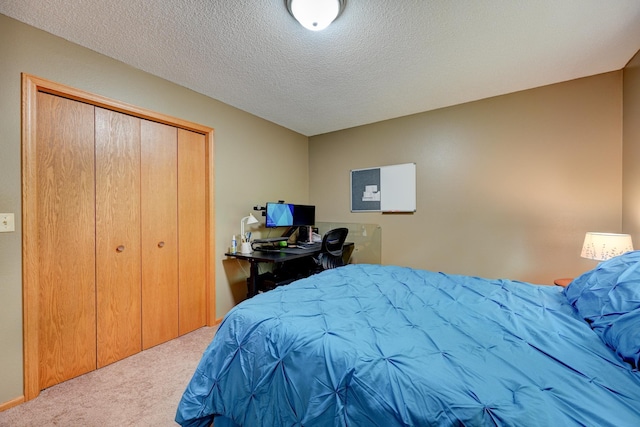 bedroom with carpet, a textured ceiling, and a closet