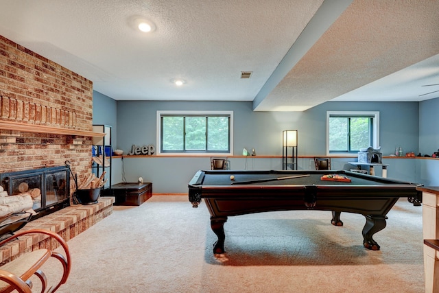 rec room with plenty of natural light, light carpet, pool table, and a brick fireplace