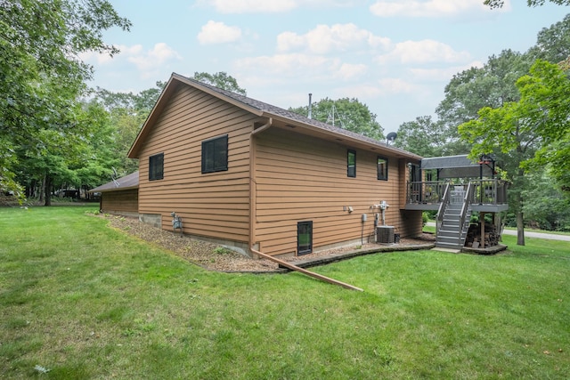 view of side of home featuring a lawn, central air condition unit, and a deck