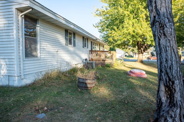 view of yard with a wooden deck and central air condition unit