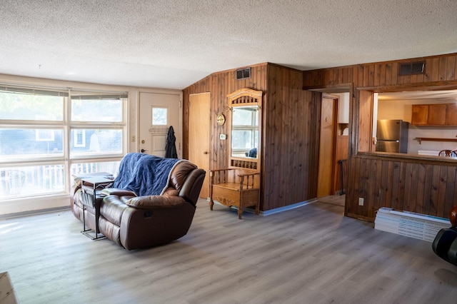 living room with hardwood / wood-style flooring, lofted ceiling, and plenty of natural light