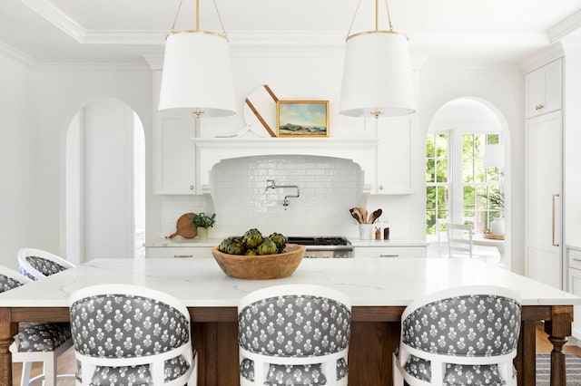 kitchen featuring decorative backsplash, white cabinetry, and a kitchen island