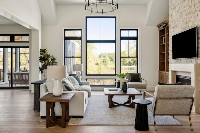 living room with hardwood / wood-style floors, a healthy amount of sunlight, built in features, and a fireplace