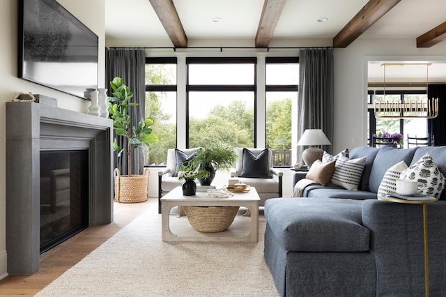 living room featuring beamed ceiling and light hardwood / wood-style floors