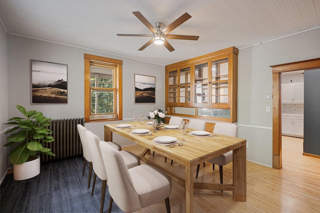 dining area with ceiling fan, radiator, light hardwood / wood-style flooring, and ornamental molding