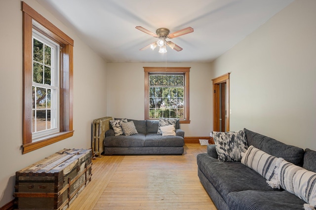 living room featuring ceiling fan, a wealth of natural light, radiator heating unit, and light hardwood / wood-style floors