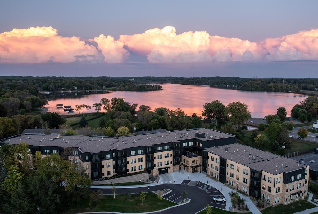 aerial view at dusk featuring a water view