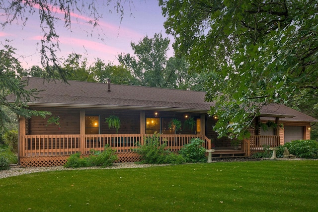 view of front facade with a yard, a porch, and a garage