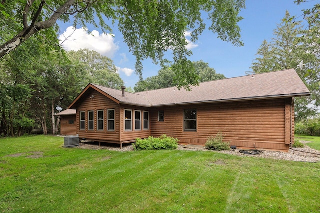 back of property featuring cooling unit and a yard