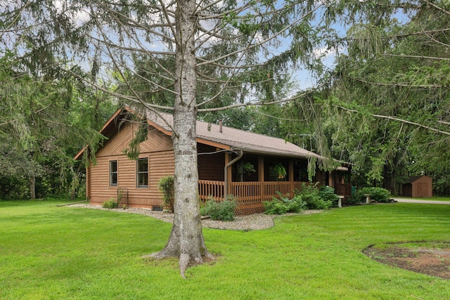 view of front of home featuring a storage shed and a front yard