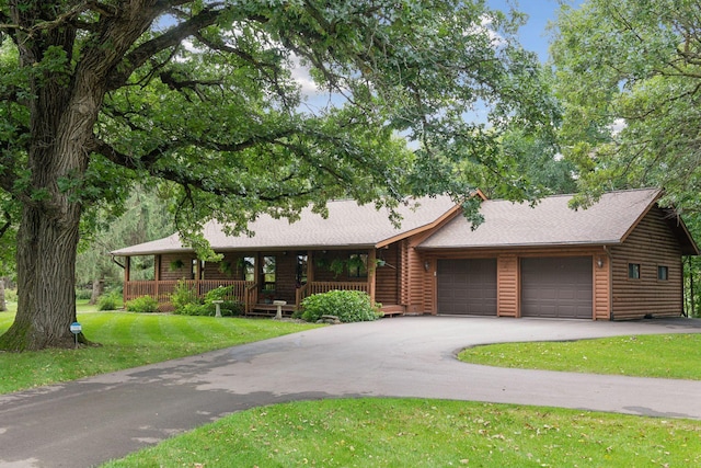 view of front of home featuring a garage, a front lawn, and a porch