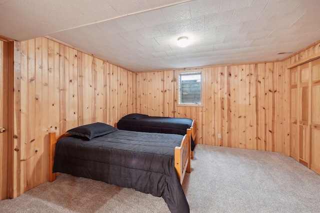 bedroom with carpet floors, a textured ceiling, and wood walls