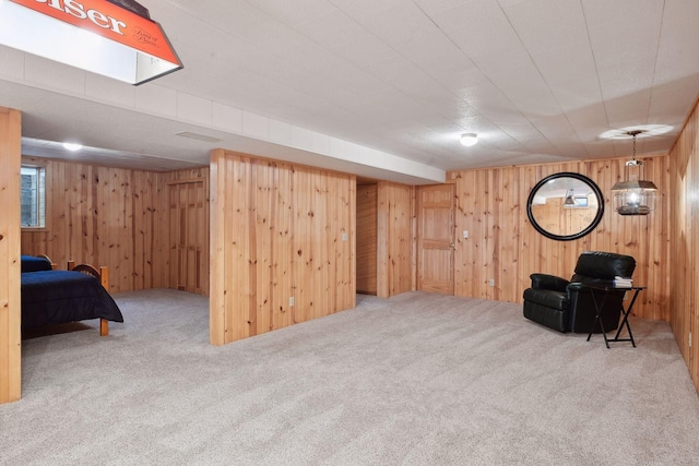 sitting room with carpet floors and wood walls