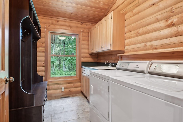 clothes washing area with independent washer and dryer, wood ceiling, sink, rustic walls, and cabinets