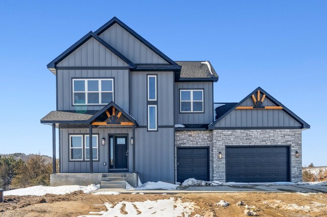 modern farmhouse style home featuring a garage, stone siding, a shingled roof, and board and batten siding