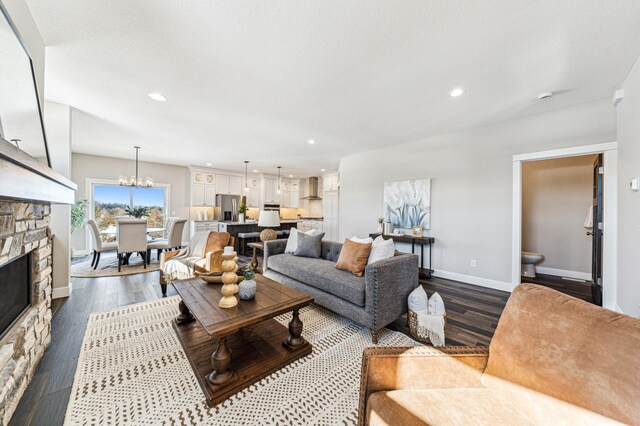 living room featuring dark wood-type flooring, a fireplace, recessed lighting, and baseboards