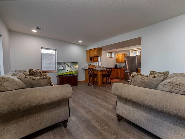 living room with bar area and wood-type flooring