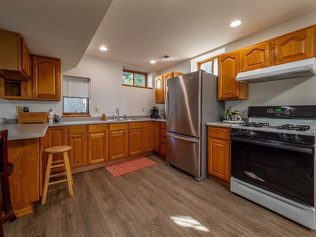 kitchen with stainless steel refrigerator, sink, white gas stove, and dark hardwood / wood-style flooring