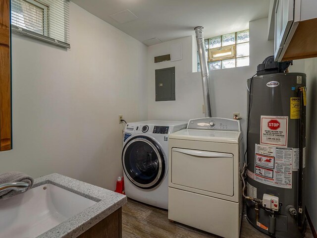 washroom featuring independent washer and dryer, sink, gas water heater, electric panel, and cabinets