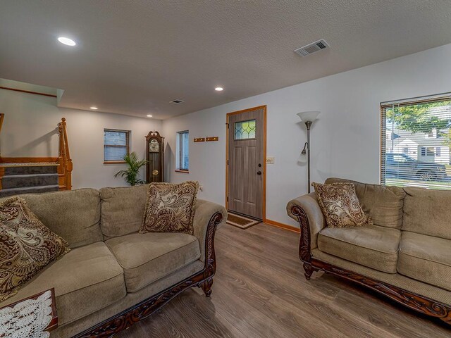 living room with wood-type flooring and a textured ceiling