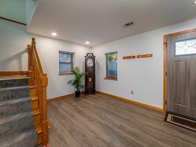 foyer entrance with hardwood / wood-style flooring and a textured ceiling