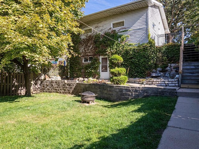 view of front of home featuring an outdoor fire pit and a front yard