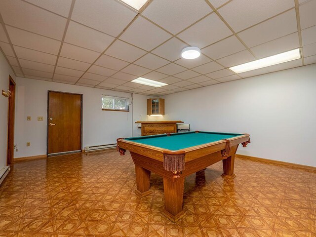 rec room with billiards, a paneled ceiling, and baseboard heating