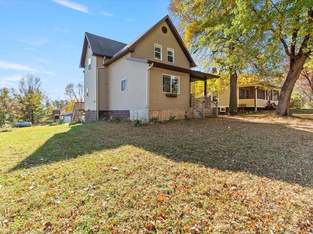 view of side of home with a lawn and a sunroom