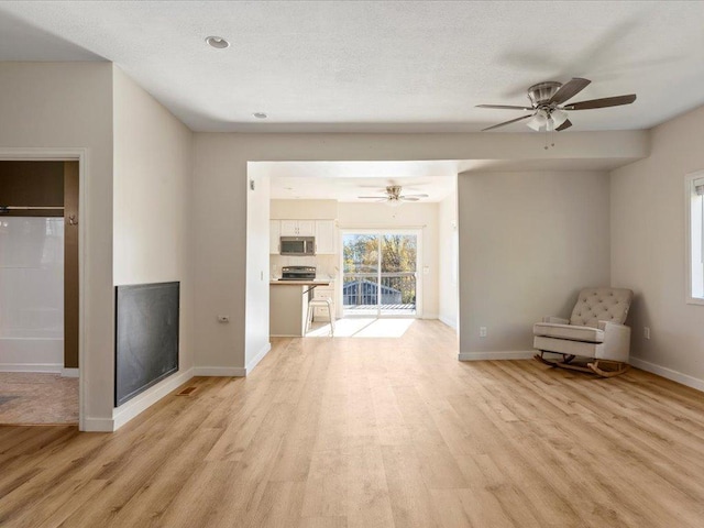 unfurnished living room with light wood-type flooring and ceiling fan