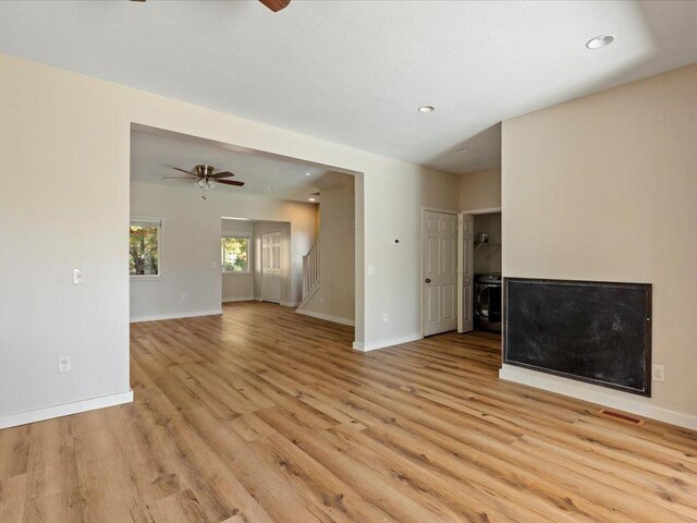 unfurnished living room featuring ceiling fan and light hardwood / wood-style floors