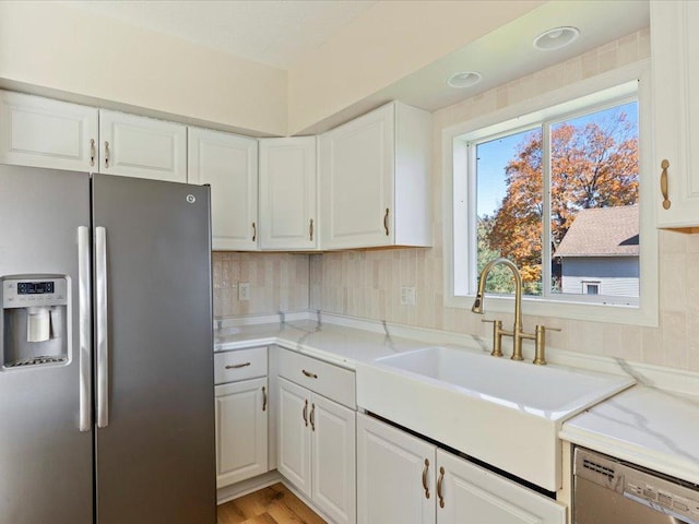 kitchen with sink, white cabinets, stainless steel appliances, and a healthy amount of sunlight