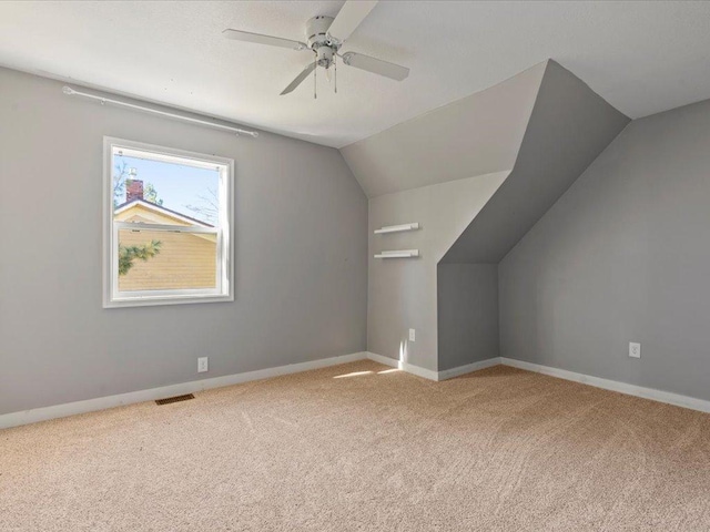 additional living space featuring carpet floors, lofted ceiling, and ceiling fan