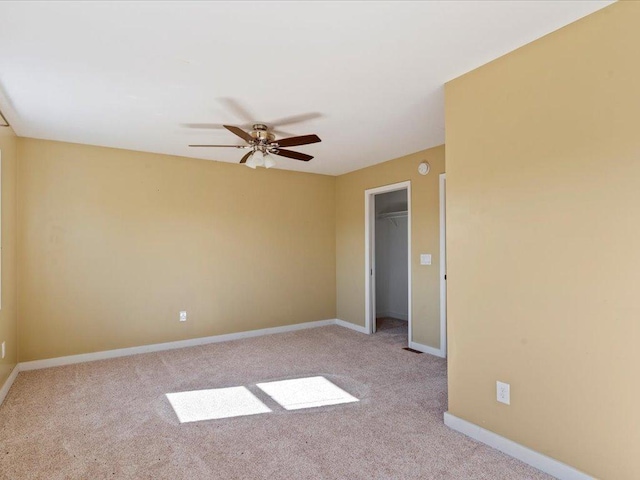 spare room with ceiling fan and light colored carpet