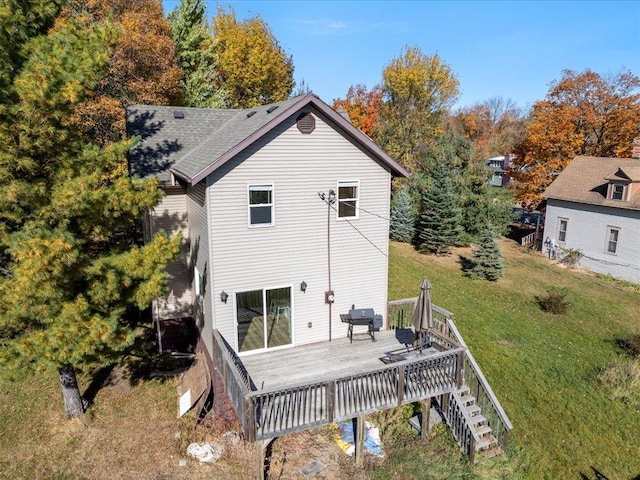 back of property with a wooden deck and a yard