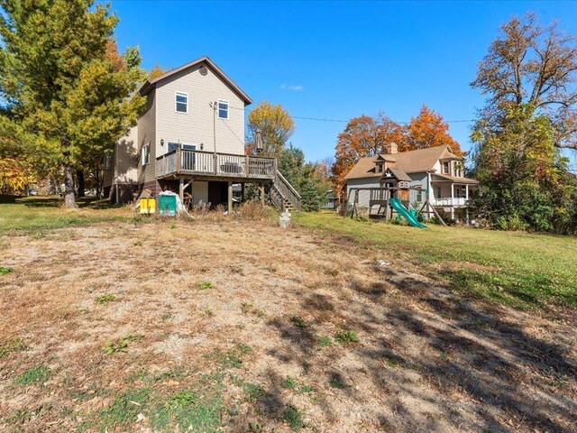 rear view of property featuring a wooden deck and a yard