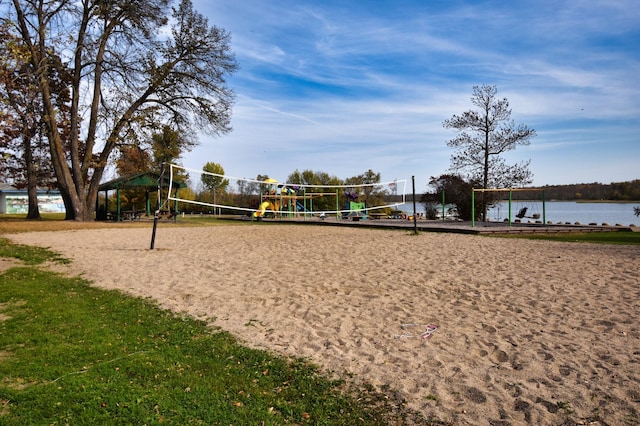 surrounding community with volleyball court and a water view