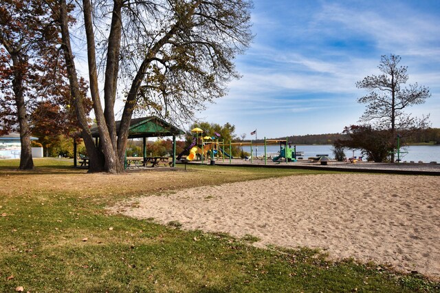 surrounding community featuring a water view, a playground, and a yard