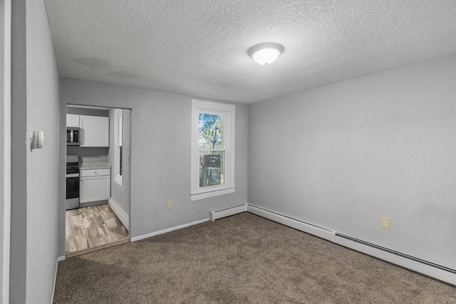 unfurnished room with carpet floors, a textured ceiling, and a baseboard heating unit