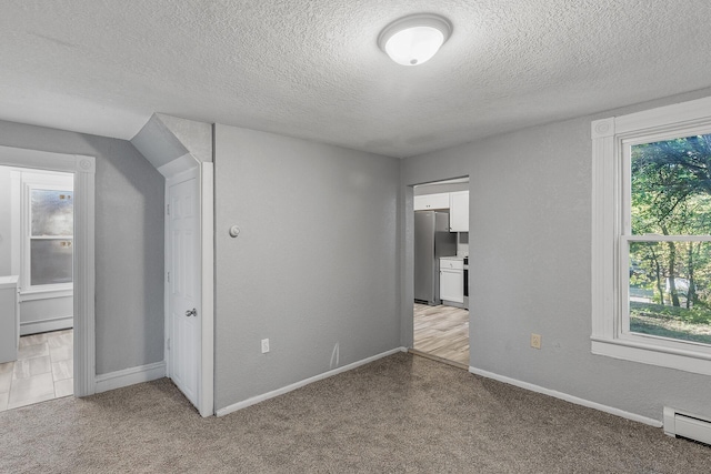 unfurnished bedroom featuring stainless steel refrigerator, light colored carpet, and multiple windows