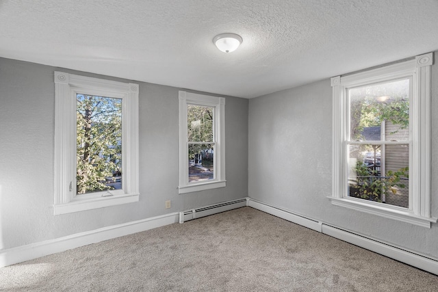 empty room featuring carpet floors, a textured ceiling, and a baseboard heating unit