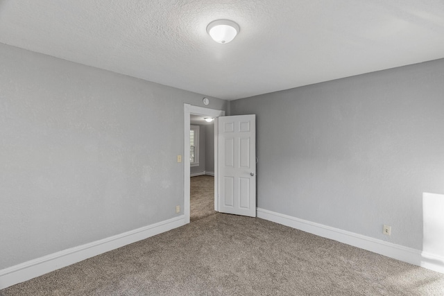 carpeted empty room with a textured ceiling