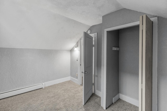 bonus room with lofted ceiling, a baseboard radiator, carpet, and a textured ceiling