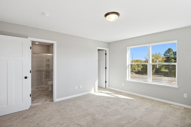 unfurnished bedroom featuring connected bathroom and light colored carpet