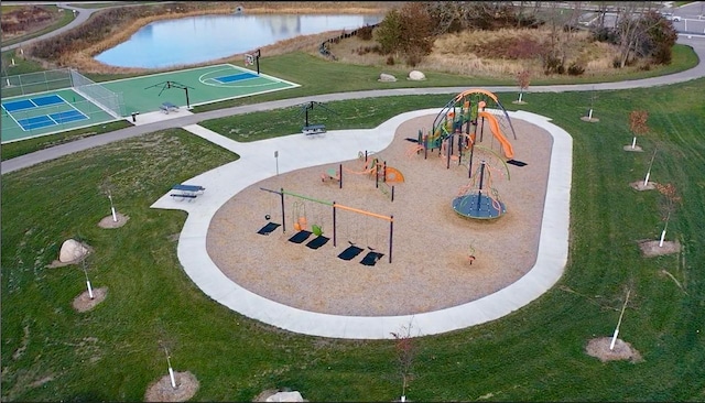 view of property's community with a playground, a lawn, and a water view