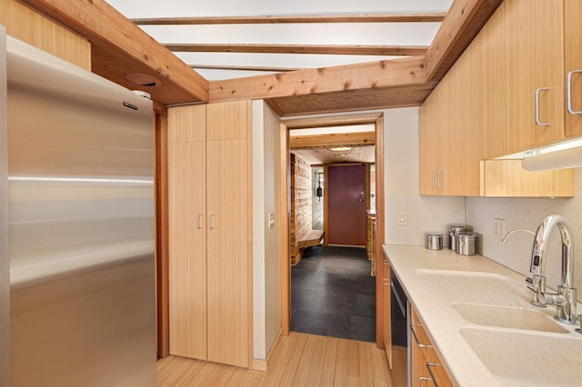 kitchen featuring light countertops, a sink, light wood finished floors, and modern cabinets