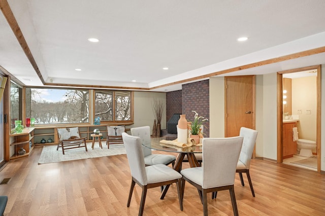 dining area with a tray ceiling, visible vents, light wood-style flooring, and recessed lighting