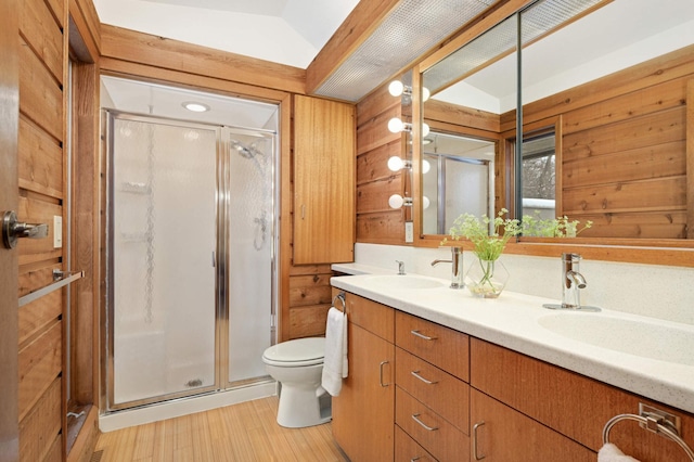 full bathroom with wood walls, a shower stall, and a sink